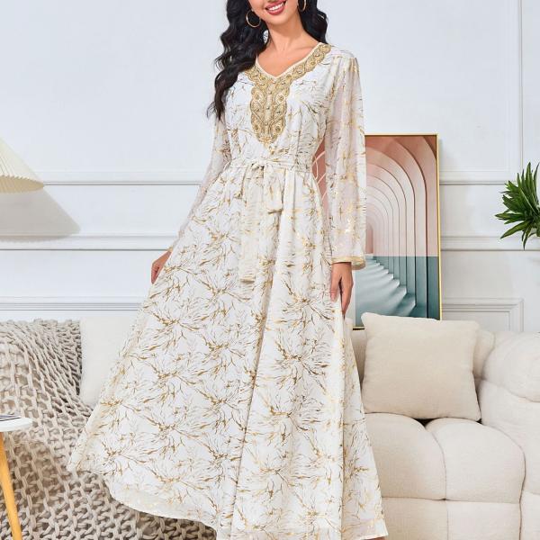 white dress embroidered with gold, a luxury that speaks of femininity