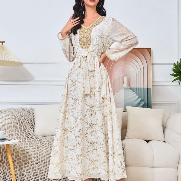 white dress embroidered with gold, a luxury that speaks of femininity